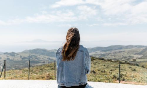 Mulher olhando para as montanhas no horizonte