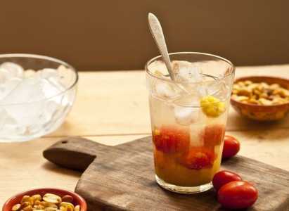 Copo com caipirinha de siriguela em uma mesa