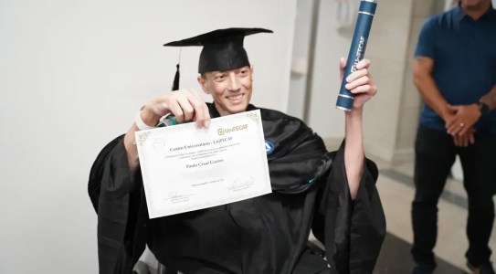 Paulo César Gazaro com roupa de formatura segurando diploma