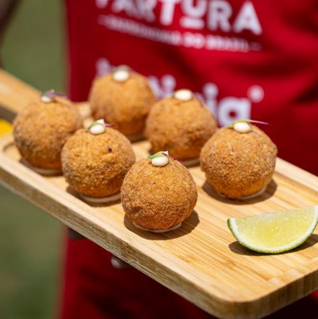 Bolinho de língua com aioli servido em uma tábua com limão