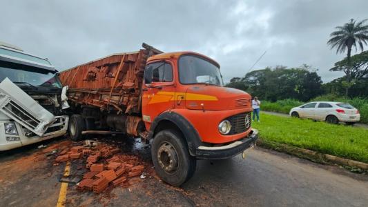 Com a batida, parte de uma carga de tijolos caiu e ficou espalhada pela rodovia.