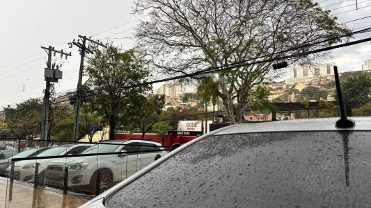 Pessoas esperam ônibus durante uma chuva forte em Belo Horizonte