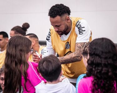 Neymar, do Santos, autografando camisas de fãs