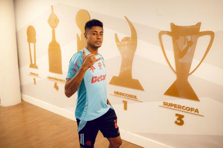 Bruno Henrique com o mural dos títulos do Flamengo no Ninho do Urubu