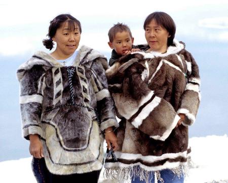 Família Inuit usando um amauti (jaqueta impermeável do Ártico caracterizado por suas costas largas, que se transformam em um capuz)