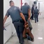 Policiais carregam homem negro com mãos e pés amarrados: 'remete à escravidão'