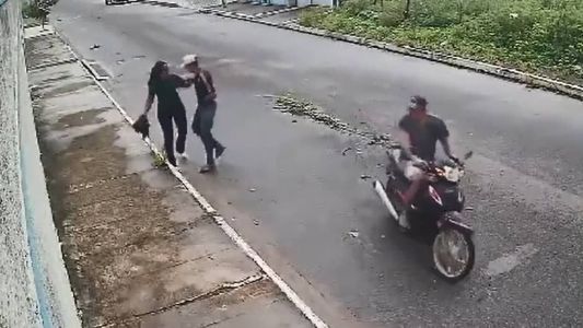 A bolsa foi arremessada por cima do muro de uma casa