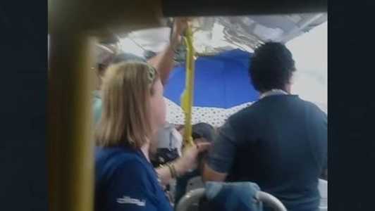 A chuva era tão forte dentro do ônibus que obrigou uma passageira a abrir o guarda-chuva