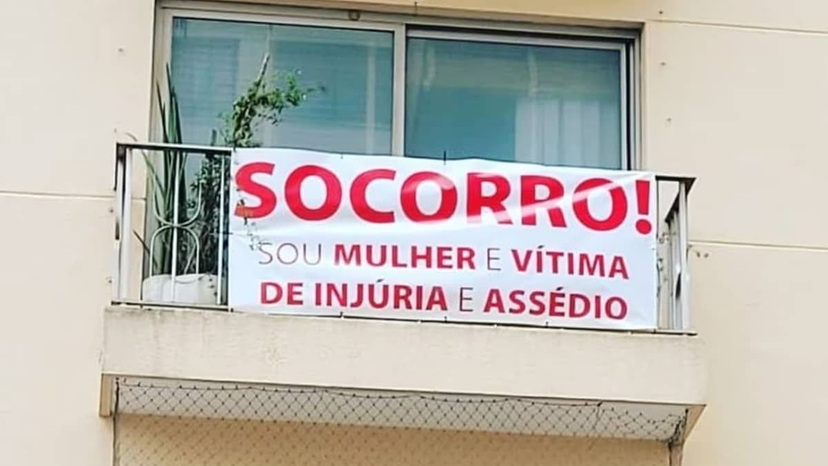 Vítima de assédio estende faixa com pedido de socorro na janela de apartamento em SP