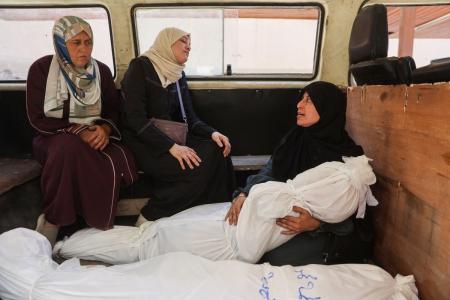 Mulher segura corpo de parente morto em ataque israelense na Faixa de Gaza