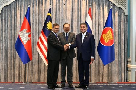 O primeiro-ministro da Malásia, Anwar Ibrahim (centro), o primeiro-ministro do Camboja, Hun Manet (esq.), e o primeiro-ministro interino da Tailândia, Phumtham Wechayachai (dir.), posam para fotos enquanto apertam as mãos após uma coletiva de imprensa após as negociações sobre um possível cessar-fogo entre Tailândia e Camboja, em Putrajaya, em 28 de julho de 2025.