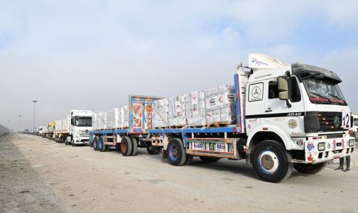 Uma imagem de folheto fornecida pela Agência de Notícias dos Emirados Árabes Unidos (WAM) em 28 de julho de 2025 mostra caminhões transportando ajuda humanitária, fornecida pela UAE AID, aguardando autorização para cruzar a fronteira egípcia de Rafah com a Faixa de Gaza