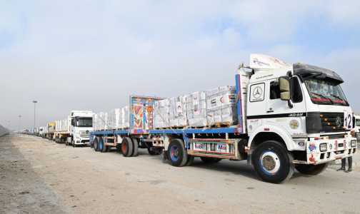 Uma imagem de folheto fornecida pela Agência de Notícias dos Emirados Árabes Unidos (WAM) em 28 de julho de 2025 mostra caminhões transportando ajuda humanitária, fornecida pela UAE AID, aguardando autorização para cruzar a fronteira egípcia de Rafah com a Faixa de Gaza