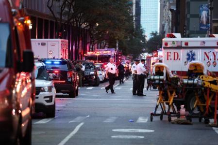 Policiais são vistos perto de veículos de emergência enquanto respondem a um tiroteio no bairro de Midtown Manhattan, em Nova York, em 28 de julho de 2025.