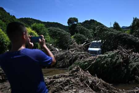 Um homem tira fotos de uma área danificada pelas fortes chuvas dos últimos dias no distrito de Huairou, nos arredores de Pequim, em 30 de julho de 2025.