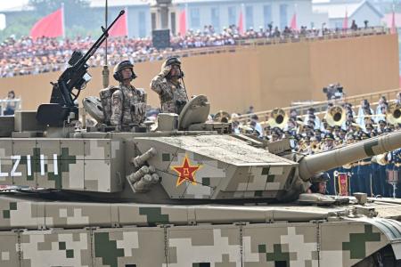 Oficiais são vistos na escotilha de um tanque de batalha principal Tipo 99 enquanto ele avança durante um desfile militar que marca o 80º aniversário da vitória sobre o Japão e o fim da Segunda Guerra Mundial, na Praça da Paz Celestial, em Pequim, em 3 de setembro de 2025.
