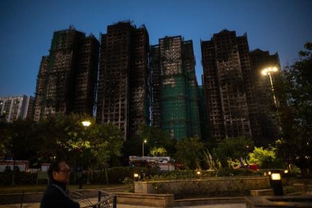 Um homem caminha em meio aos destroços de um grande incêndio que devastou vários blocos de apartamentos no conjunto residencial Wang Fuk Court, no distrito de Tai Po, em Hong Kong, em 28 de novembro de 2025