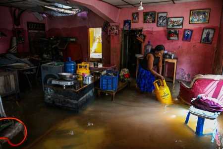 Um morador carrega um cilindro de GLP (gás liquefeito de petróleo) através de uma casa inundada após as enchentes repentinas causadas pelo ciclone Ditwah, em Wellampitiya, nos arredores de Colombo, em 3 de dezembro de 2025