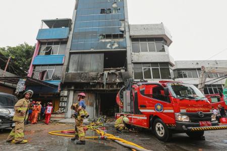 Bombeiros são vistos no local onde extinguiram um incêndio que matou pelo menos 20 pessoas em um prédio de sete andares no centro de Jacarta, em 9 de dezembro de 2025