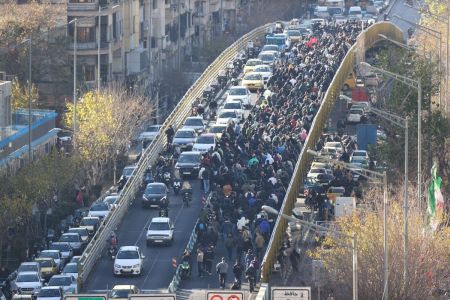 Lojistas e comerciantes atravessam uma ponte durante um protesto contra a situação econômica e a desvalorização da moeda iraniana em Teerã, em 29 de dezembro de 2025.