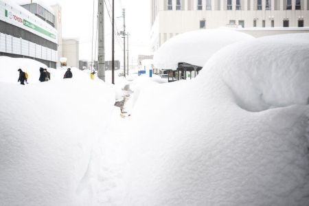 Pedestres tentam caminhar em meio a neve em Aomori