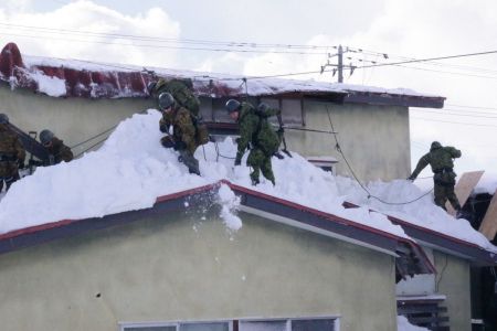 Militares japoneses ajudam a retirar neves dos telhados em Aimori