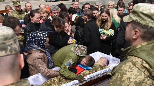 Amigos e familiares enterram soldado ucraniano morto durante a guerra na cidade de Lviv; a fotografia é de 28 de abril de 2022