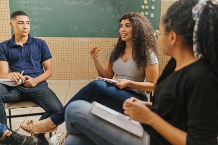três estudantes em sala de aula