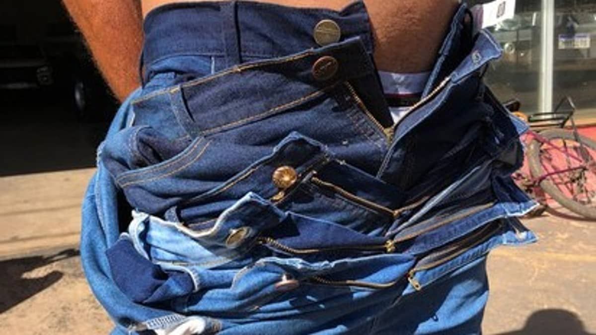 Homem vestindo três calças e duas bermudas é preso suspeito de furtar peças em Minas