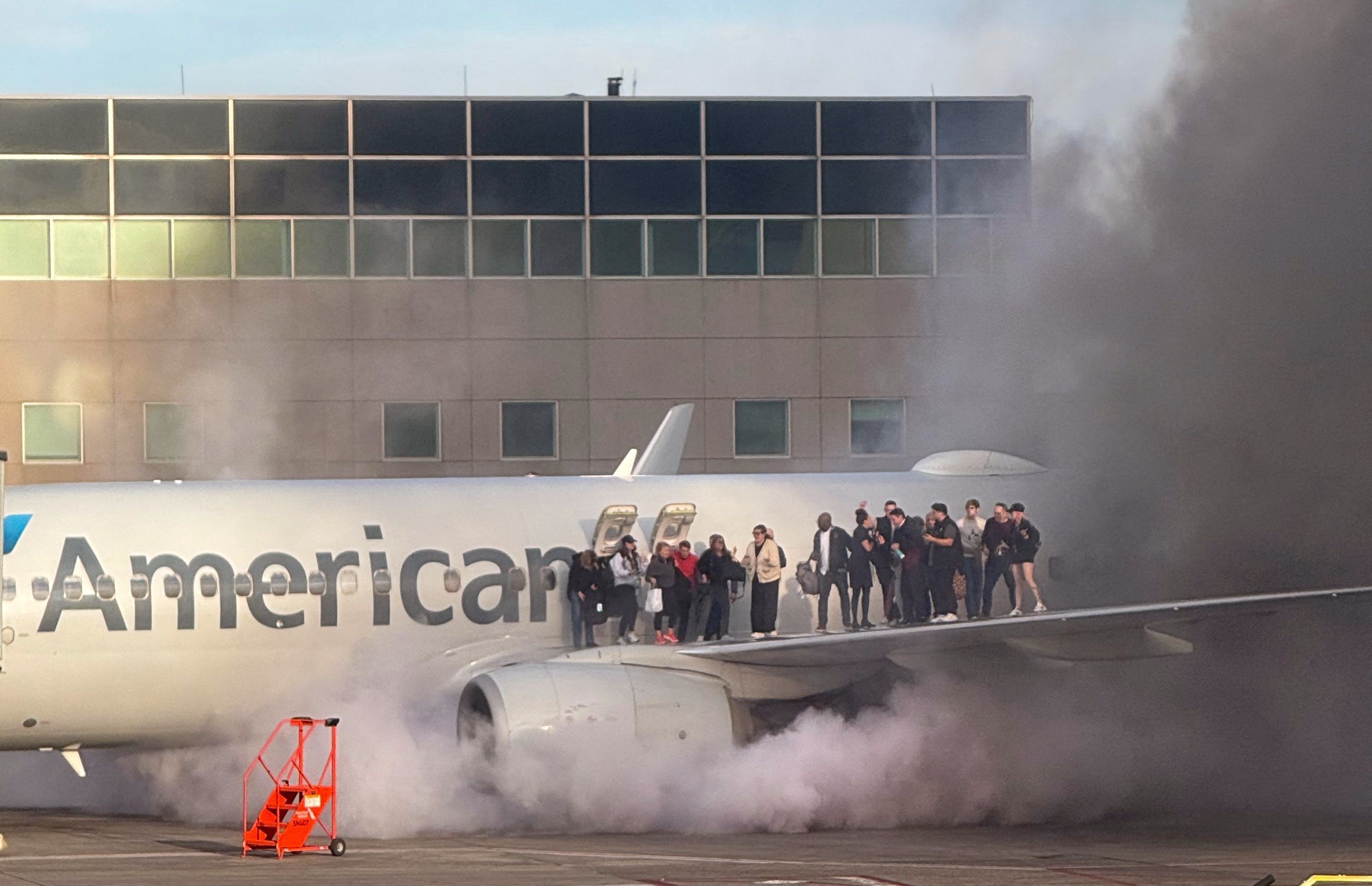Avião da American Airlines pega fogo e passageiros ficam presos na asa; veja vídeo