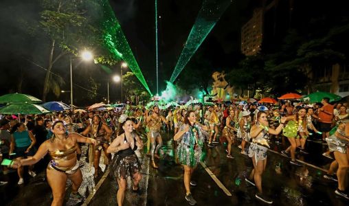 Foto mostra movimentação de foliões e show de luzes durante o bloco Chama o Síndico
