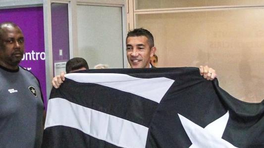 Bruno Lage com a bandeira do Botafogo no desembarque no Rio de Janeiro