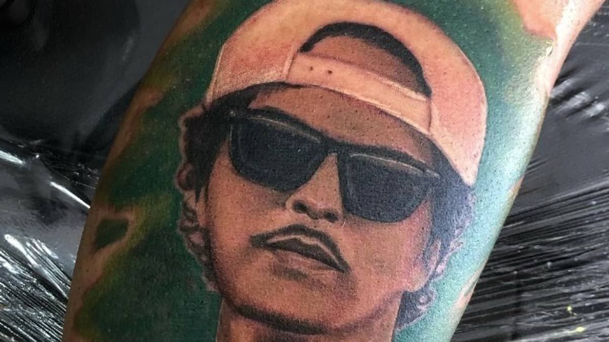 Bruno Mars compartilha tatuagem de fã brasileira com seu rosto nas redes sociais: 'zerei a vida'