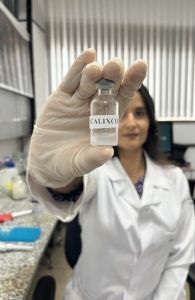 Pesquisadora exibe frasco da vacina