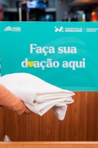 Imagem mostra agasalho sendo doado em caixa de papelão