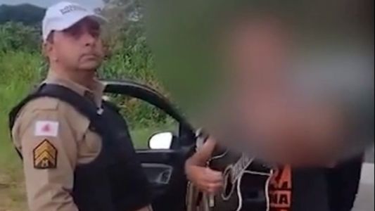 Foto mostra policial ouvindo motorista bêbado cantar durante abordagem policial em Passos (MG)