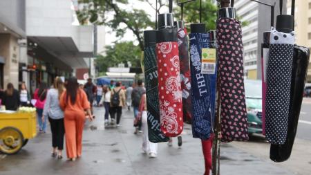 Pedestres na Avenida Paulista durante a chegada da frente fria