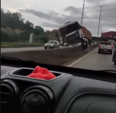 Carreta vai parar em cima da mureta na Fernão Dias, em Betim