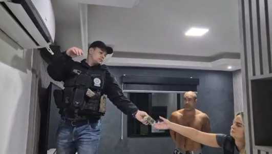 policial retira maço de dinheiro que estava escondido no teto da mansão onde suspeito mora