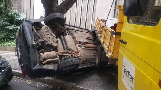 Carro ficou de lado, prensado e com três rodas para o alto