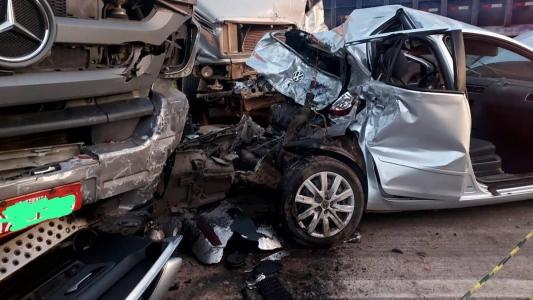 Carro ficou preso entre dois caminhões na MG-050