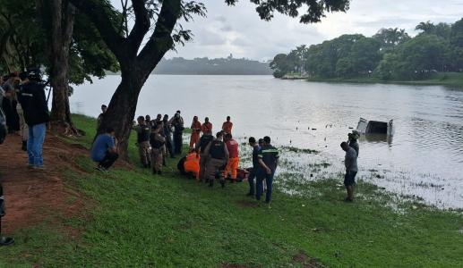 Foto mostra veículo dentro da Lagoa da Pampulha e agentes do Corpo de Bombeiros resgatando a vítima