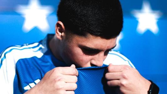 Cauan Baptistella beija escudo do Cruzeiro em anúncio de novo contrato, em julho de 2025