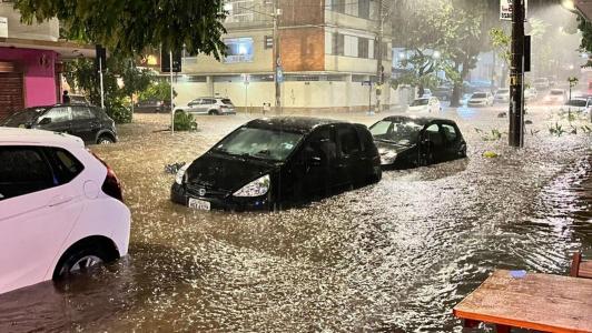 Foto mostra carros parcialmente submersos em cruzamento no bairro Savassi