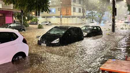 Foto mostra carros parcialmente submersos em cruzamento no bairro Savassi