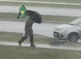 Manifestante debaixo de chuva em Brasília