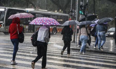 Pessoas caminhando em dia chuvoso em São Paulo