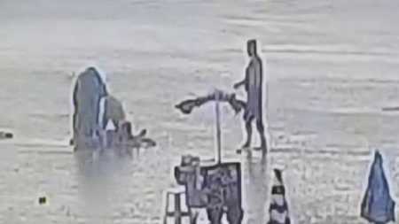 Foto mostra vítima sendo socorrida em praia no litoral de São Paulo