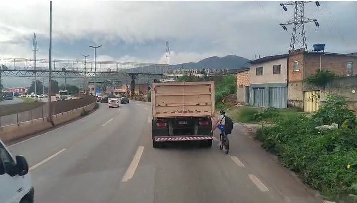 Ciclista se arrisca ao pegar traseira em carreta no Anel Rodoviário de BH