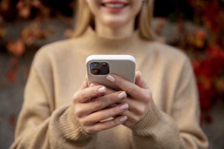 Imagem de jovem mexendo em iphone, celular da Apple